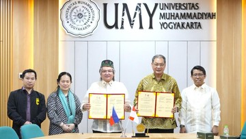 Para perwakilan UMY dan MSU-IIT memegang dokumen kerja sama di depan latar Universitas Muhammadiyah Yogyakarta